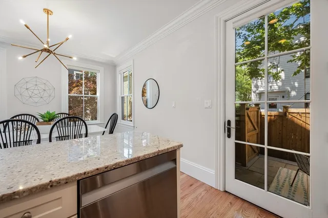 a dining table with a large window and potted plants