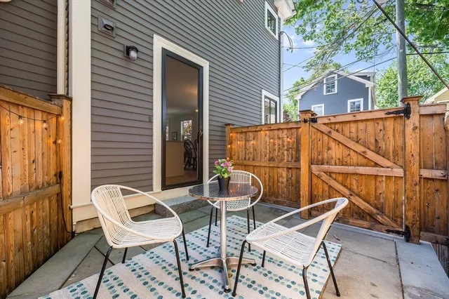 a patio with table and chairs and potted plants