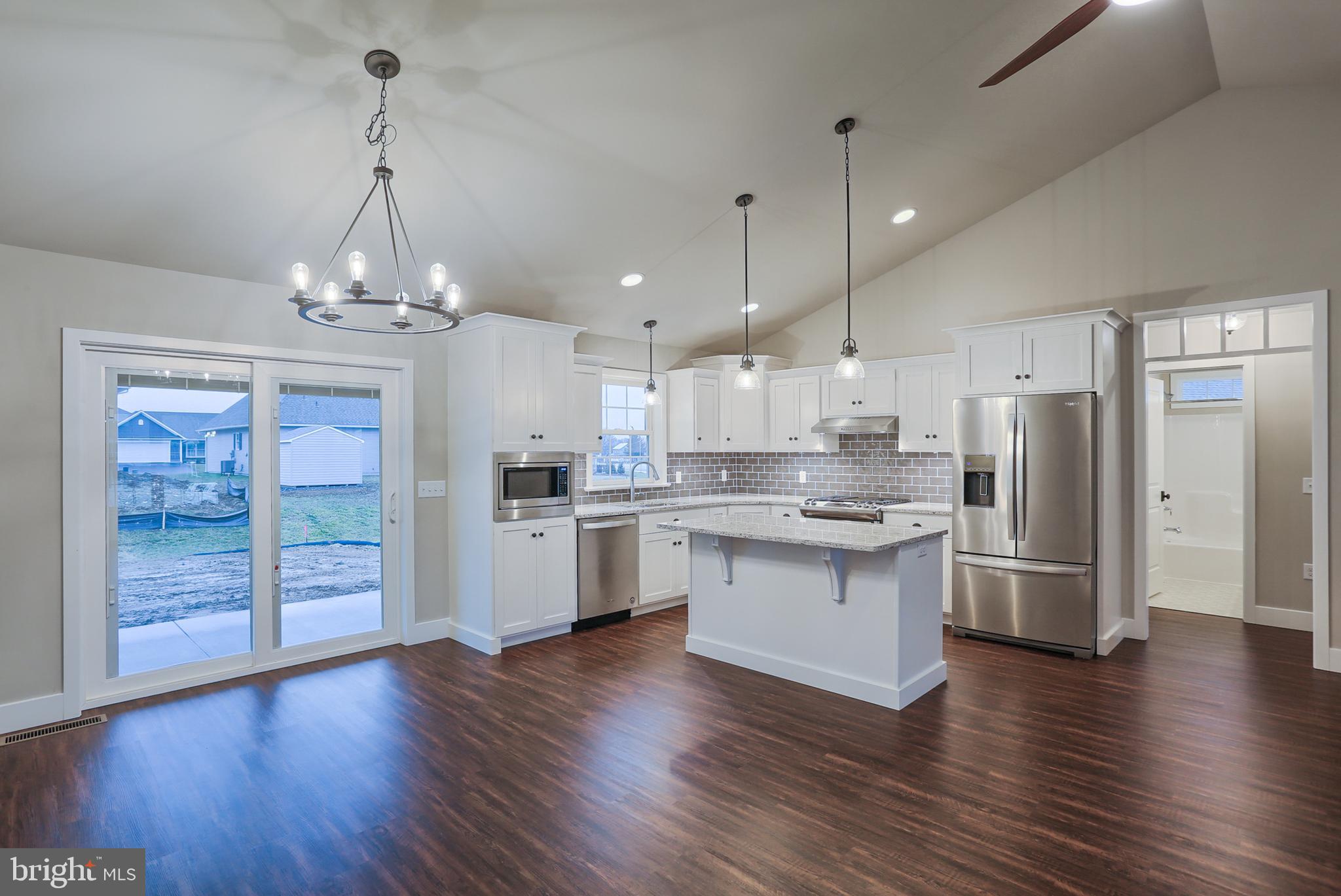 16 Rolling Meadow Road Lebanon, PA 17046 - Photo 4 of 21 a kitchen with stainless steel appliances granite countertop a refrigerator a sink dishwasher a kitchen island with wooden floor and cabinets
