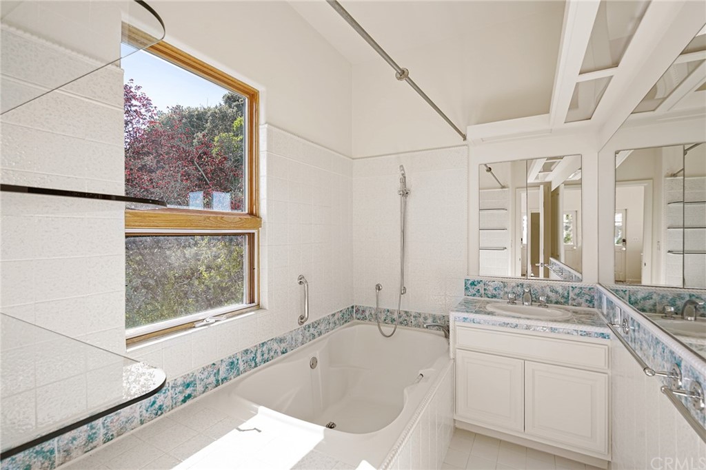 95 Hiller Drive Oakland, CA 94618 - Photo 35 of 58 a bathroom with a granite countertop sink mirror and a bathtub