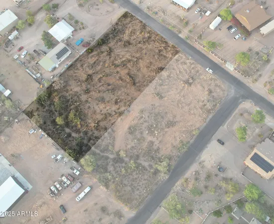 a view of a dry yard with wooden floor and fence