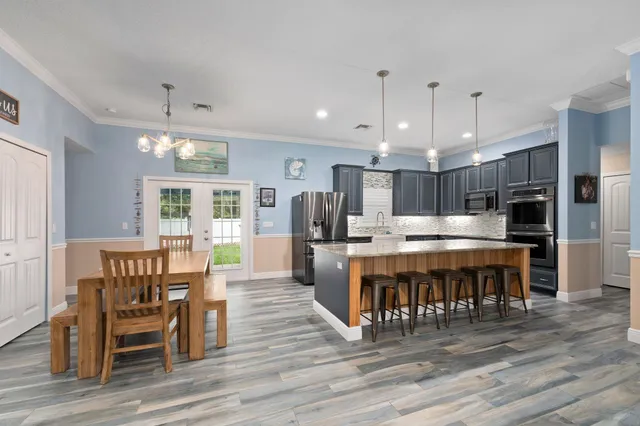 a bed sitting in a bedroom next to a window with a chandelier
