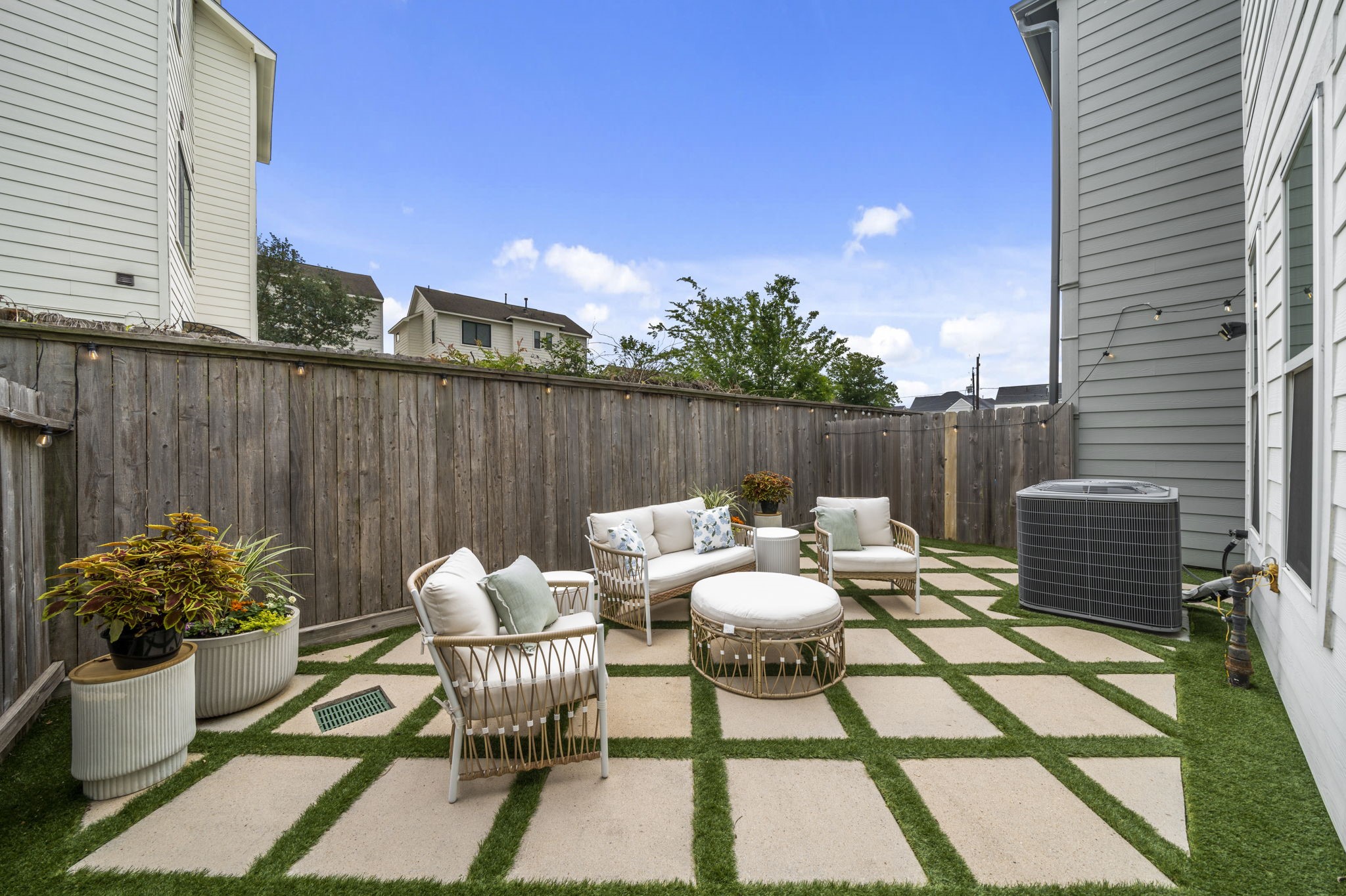 9018 Wellspring Drive Houston, TX 77080 - Photo 19 of 25 Escape to your private, low-maintenance retreat. The backyard features a stylish geometric paver design interwoven with high-quality artificial turf, creating a perfect year-round space for outdoor lounging and entertaining.
