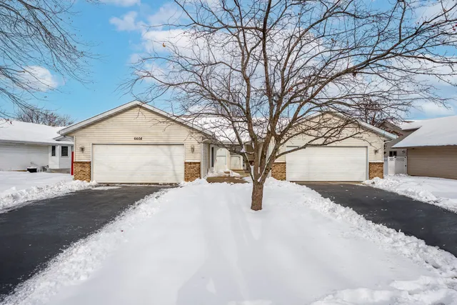 a yellow house with snow on the road