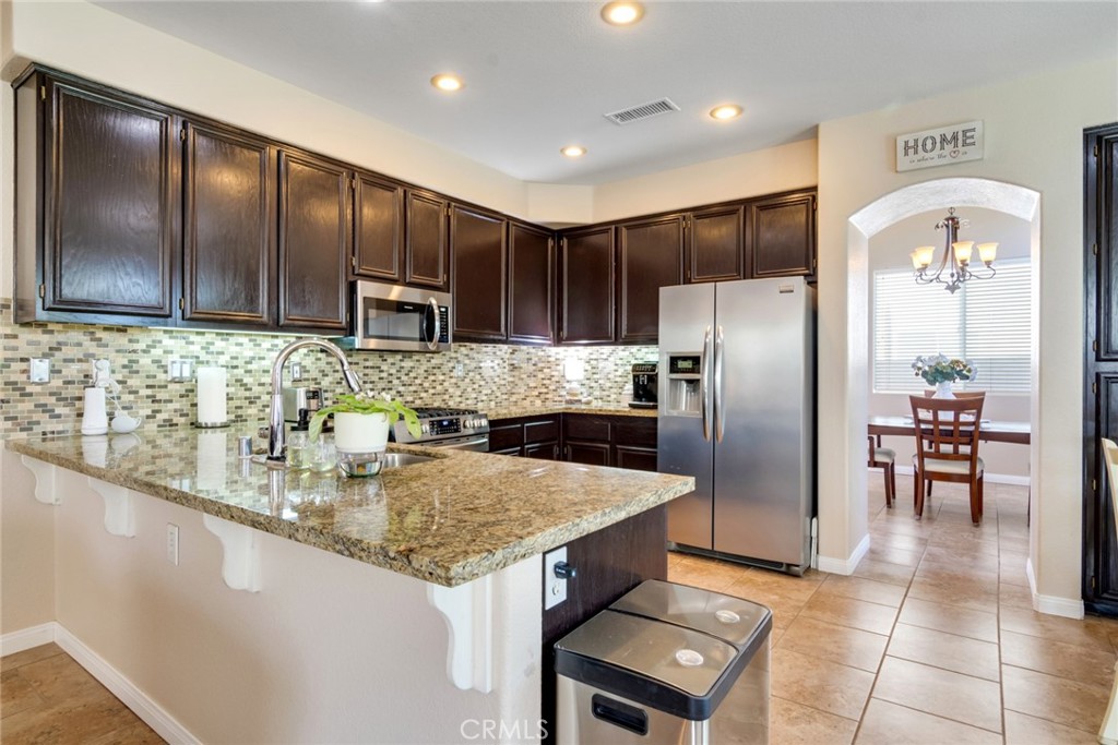 20885 Bakal Drive Riverside, CA 92508 - Photo 12 of 47 a kitchen with stainless steel appliances granite countertop a sink refrigerator and cabinets