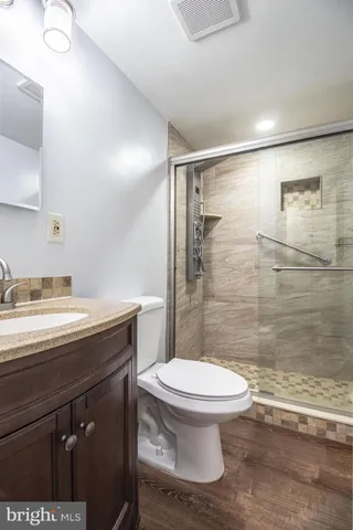 a bathroom with a granite countertop sink toilet and shower