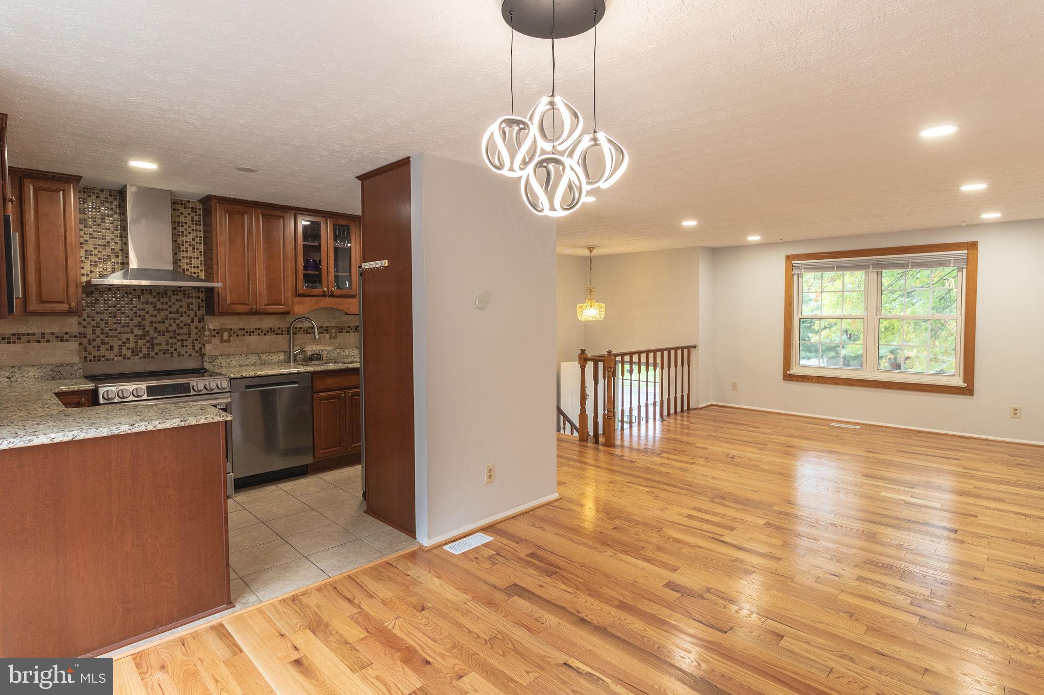 8764 Cold Plain Court Springfield, VA 22153 - Photo 5 of 24 a kitchen with stainless steel appliances granite countertop a sink a stove a refrigerator cabinets and a dining table
