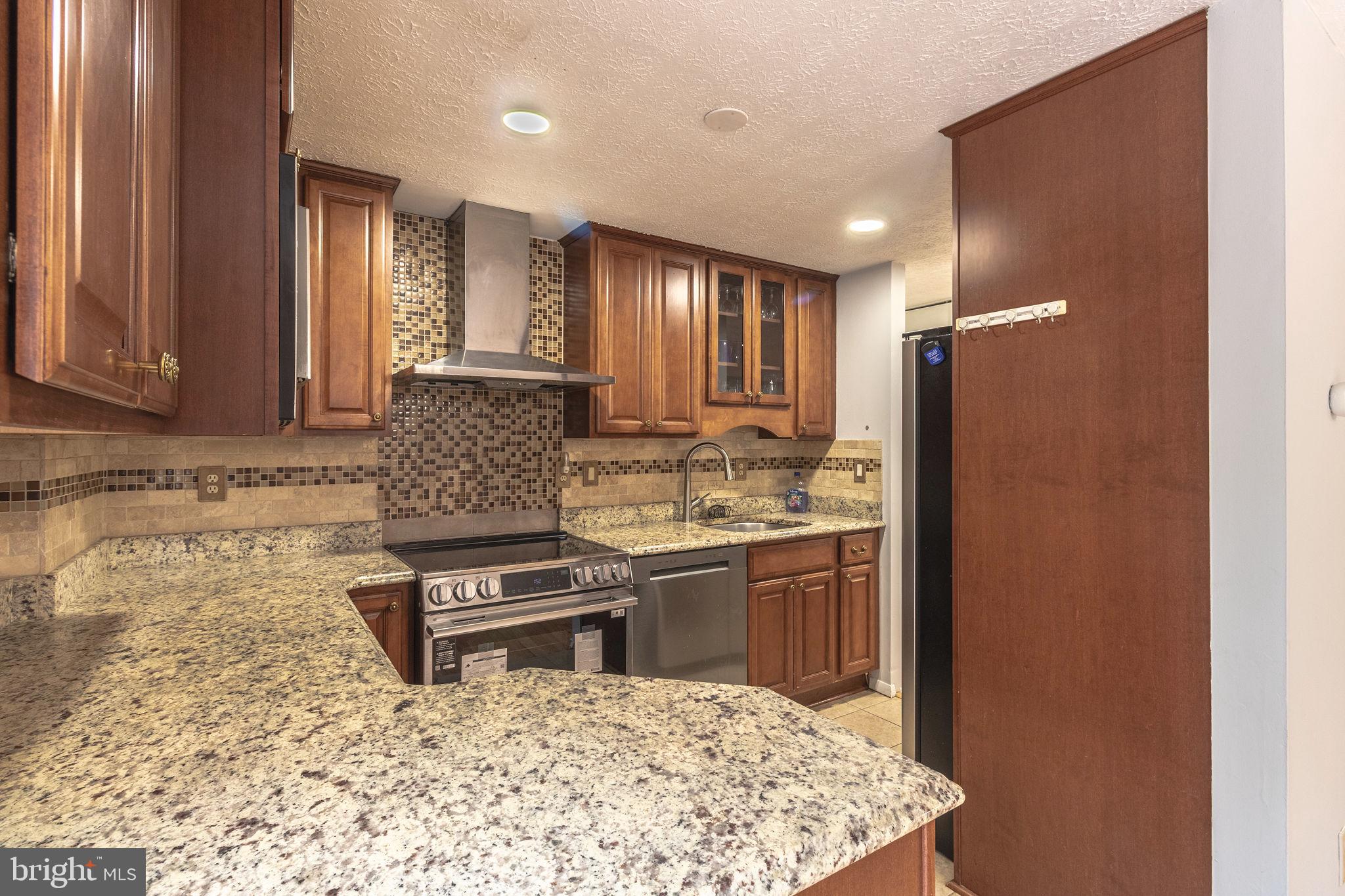 8764 Cold Plain Court Springfield, VA 22153 - Photo 6 of 24 a kitchen with stainless steel appliances granite countertop a refrigerator and a stove top oven
