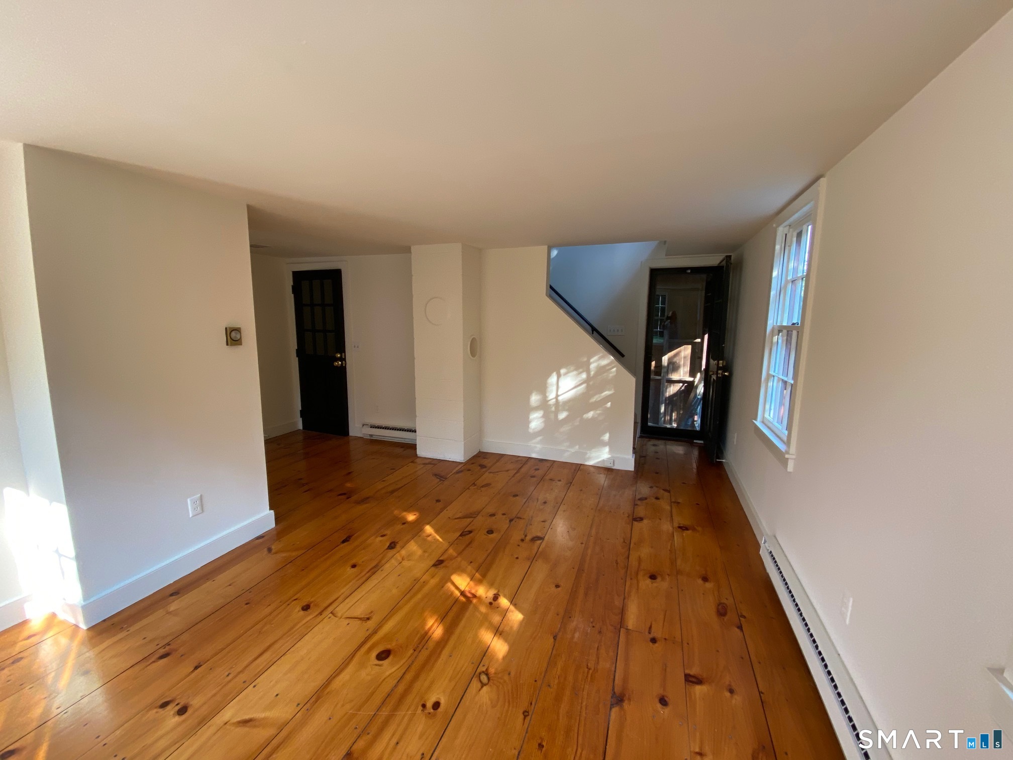 95 R Saybrook Road Essex, CT 06426 - Photo 10 of 17 Living Room with door to small covered porch and staircase down to yard. Door on left leads to staircase to Tavern Room