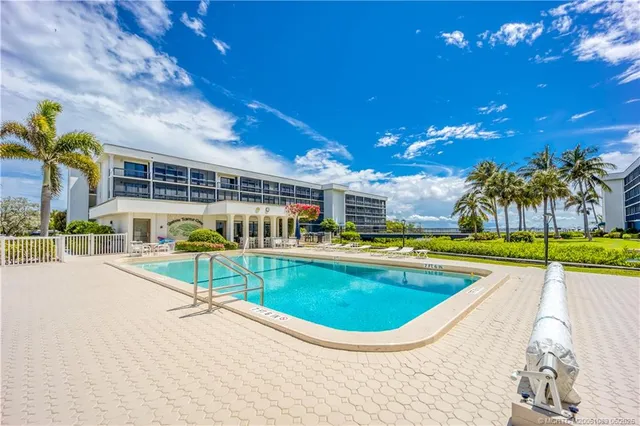 a view of a swimming pool with a patio and a yard