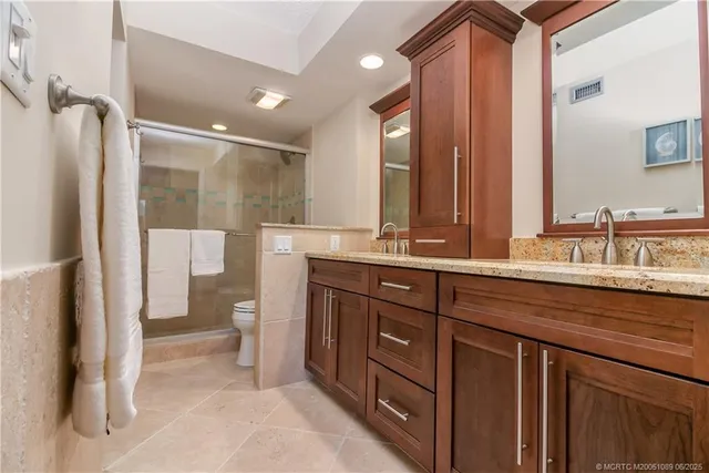 a bathroom with a double vanity sink toilet and shower
