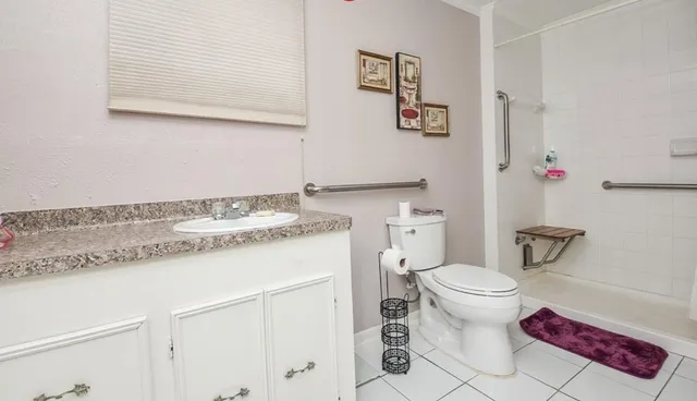 a bathroom with a granite countertop toilet sink and a mirror