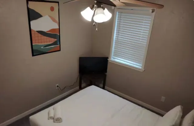 a bedroom with a bed and a painting on the wall