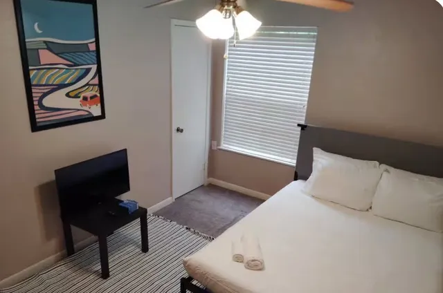 a bedroom with a bed and a window