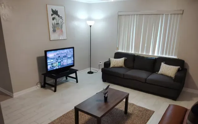 a living room with furniture a rug and a window