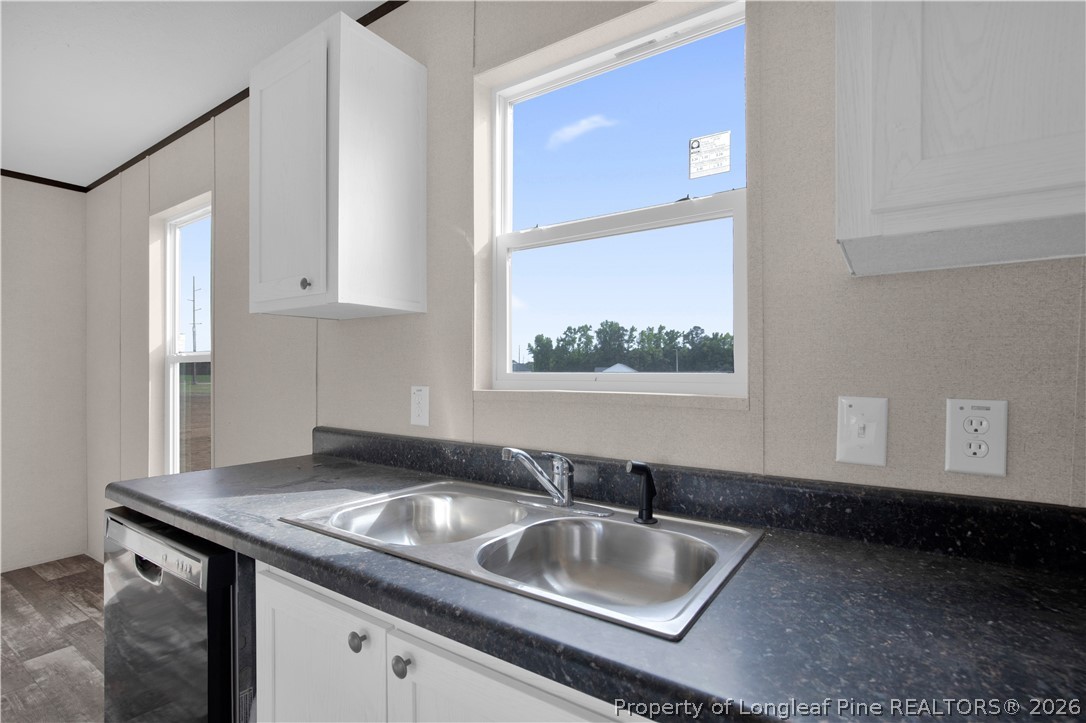 6309 Deep Branch Road Pembroke, NC 28372 - Photo 11 of 32 a kitchen with granite countertop a sink stove and cabinets