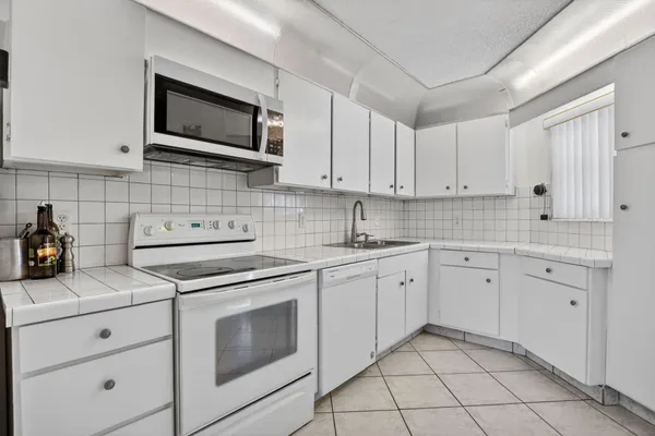 a kitchen with cabinets stainless steel appliances and sink
