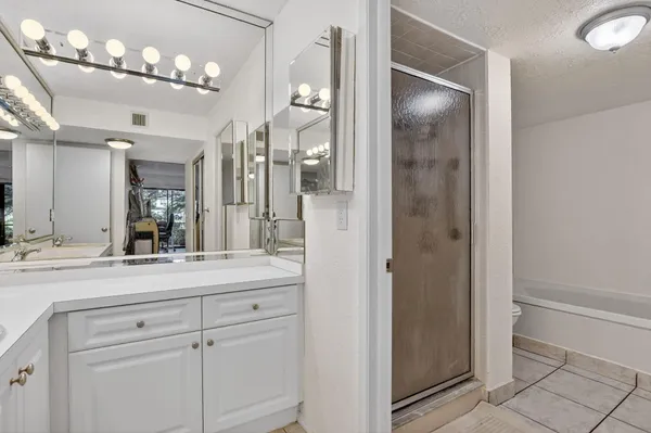 a bathroom with a sink shower and a mirror