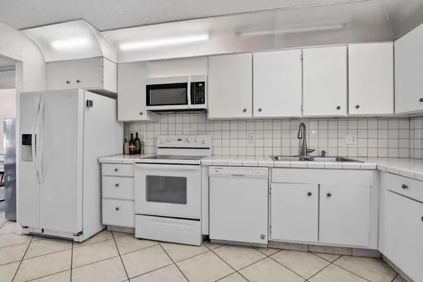 a kitchen with white cabinets stainless steel appliances and sink