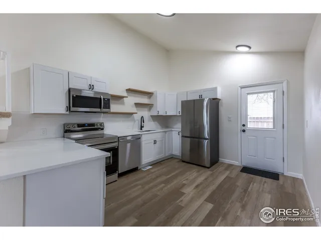 a kitchen with granite countertop a refrigerator stove and sink
