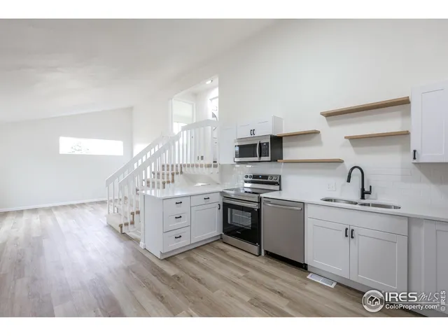 a view of a kitchen with wooden floor and electronic appliances