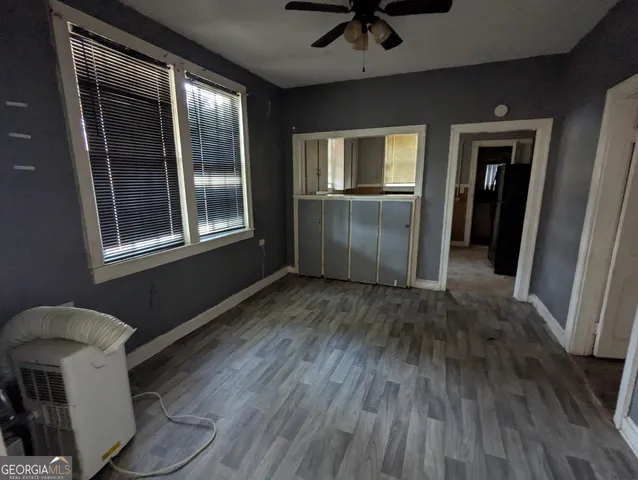 a view of empty room with wooden floor and fan