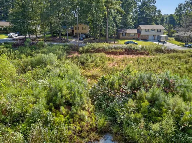 a view of backyard with swimming pool and seating space