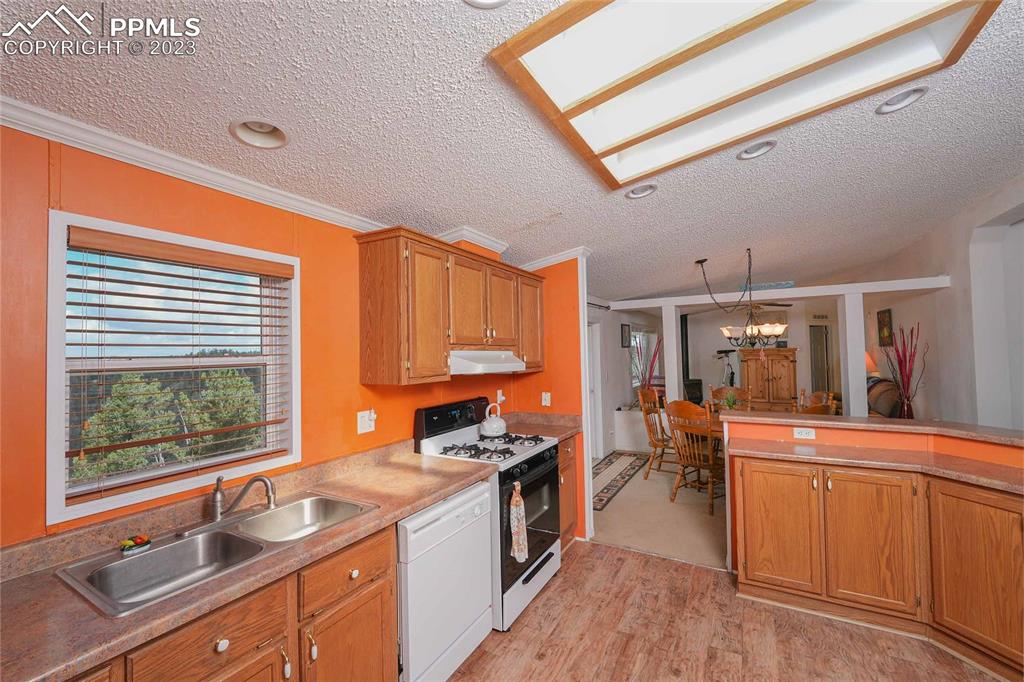 187 Blue Spruce Road Divide, CO 80814 - Photo 4 of 31 a kitchen with stainless steel appliances granite countertop a sink stove and wooden cabinets