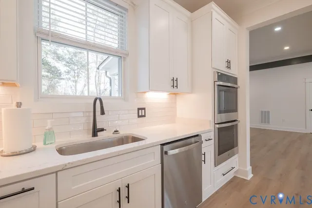 a kitchen with stainless steel appliances a sink a stove and a refrigerator
