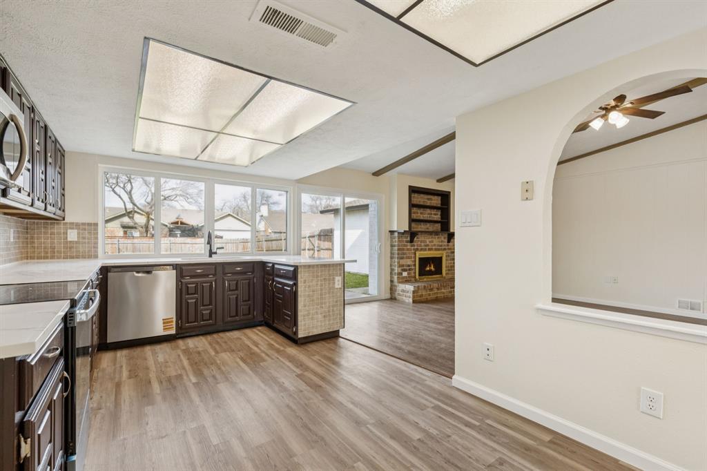 9305 Pollard Street Rowlett, TX 75088 - Photo 12 of 30 a kitchen with stainless steel appliances granite countertop a lot of counter space and wooden floors