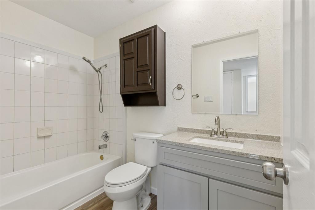 9305 Pollard Street Rowlett, TX 75088 - Photo 14 of 30 a bathroom with a sink a toilet and a bathtub
