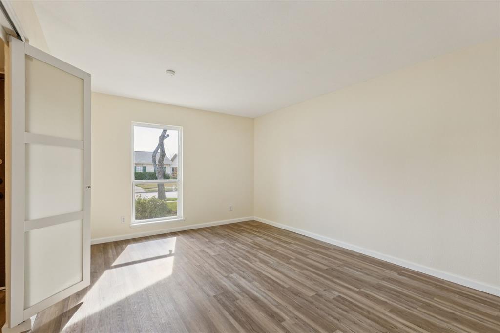 9305 Pollard Street Rowlett, TX 75088 - Photo 2 of 30 an empty room with wooden floor and windows