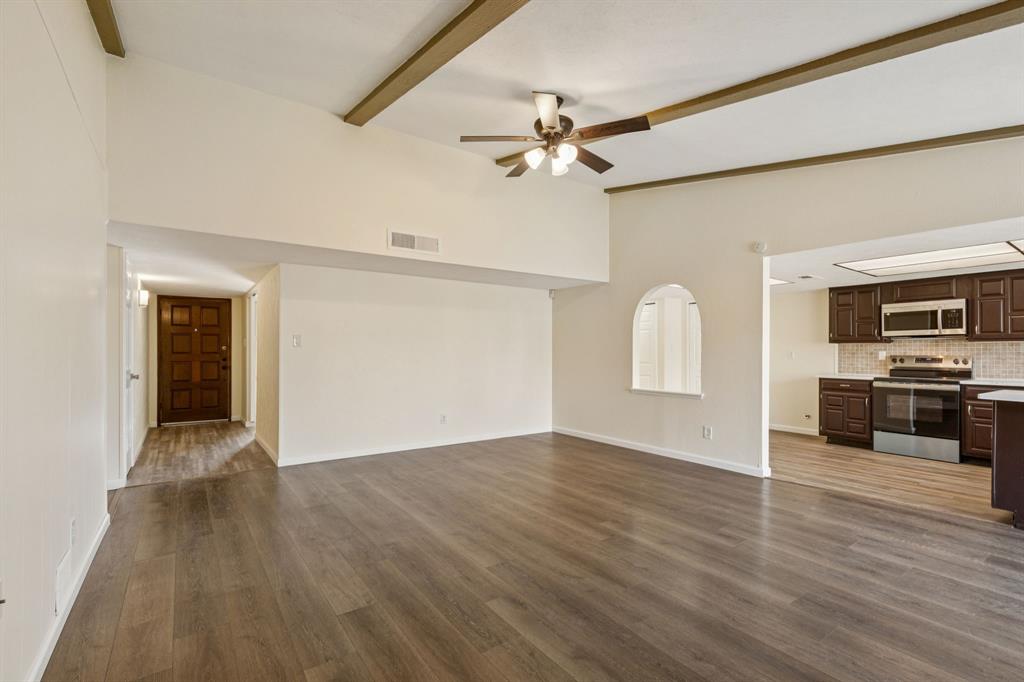 9305 Pollard Street Rowlett, TX 75088 - Photo 6 of 30 an empty room with wooden floor ceiling fan and windows