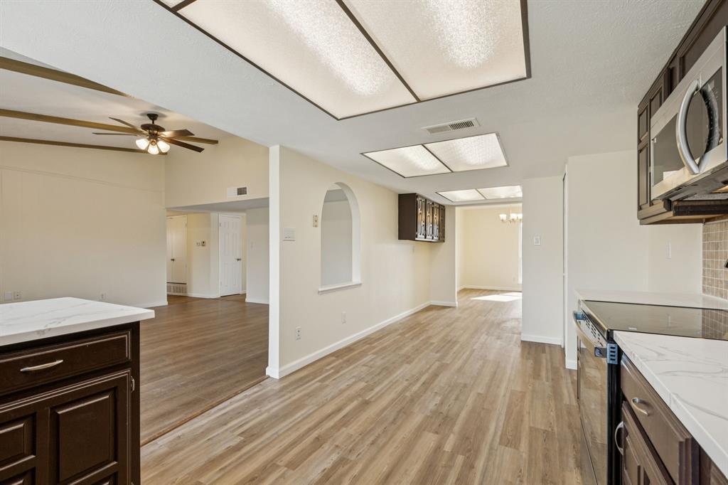 9305 Pollard Street Rowlett, TX 75088 - Photo 9 of 30 a view of a kitchen cabinets a wooden floor and a ceiling fan