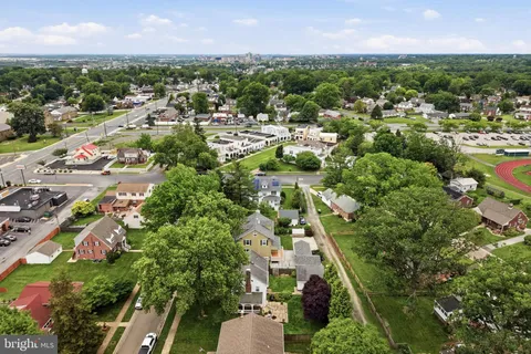 an aerial view of residential houses with outdoor space and trees