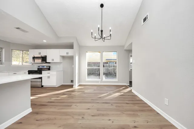 a view of a livingroom with a fireplace a ceiling fan and wooden floor