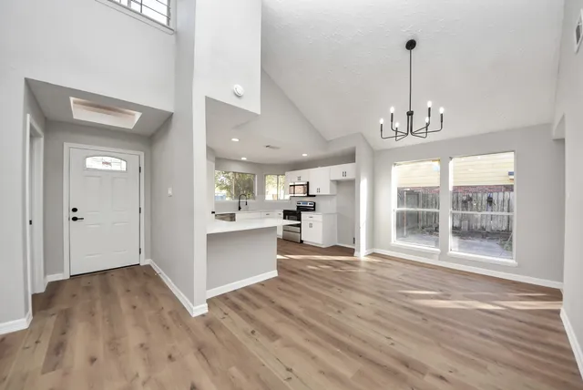 a kitchen with white cabinets and window