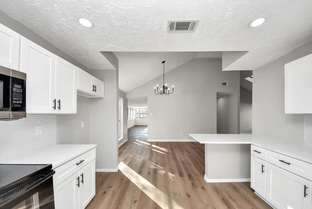 a kitchen with stainless steel appliances kitchen island granite countertop a sink stove and cabinets