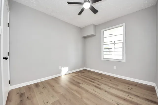 a view of empty room with wooden floor
