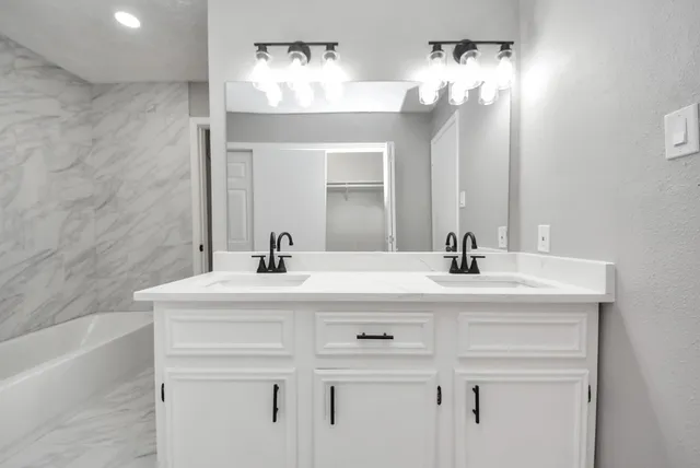 a bathroom with a double vanity sink mirror and