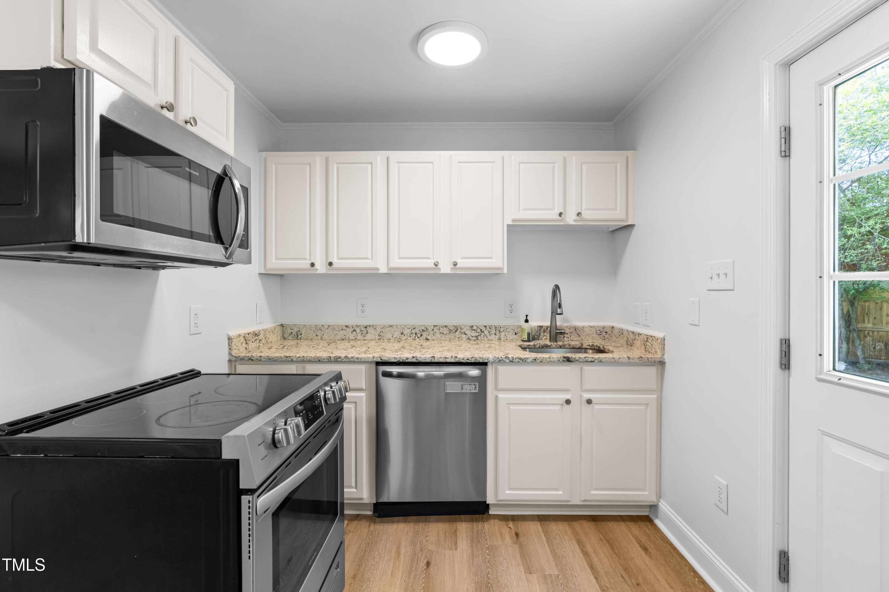 705 Hartford Road Raleigh, NC 27610 - Photo 11 of 24 a kitchen with stainless steel appliances granite countertop a sink stove and microwave