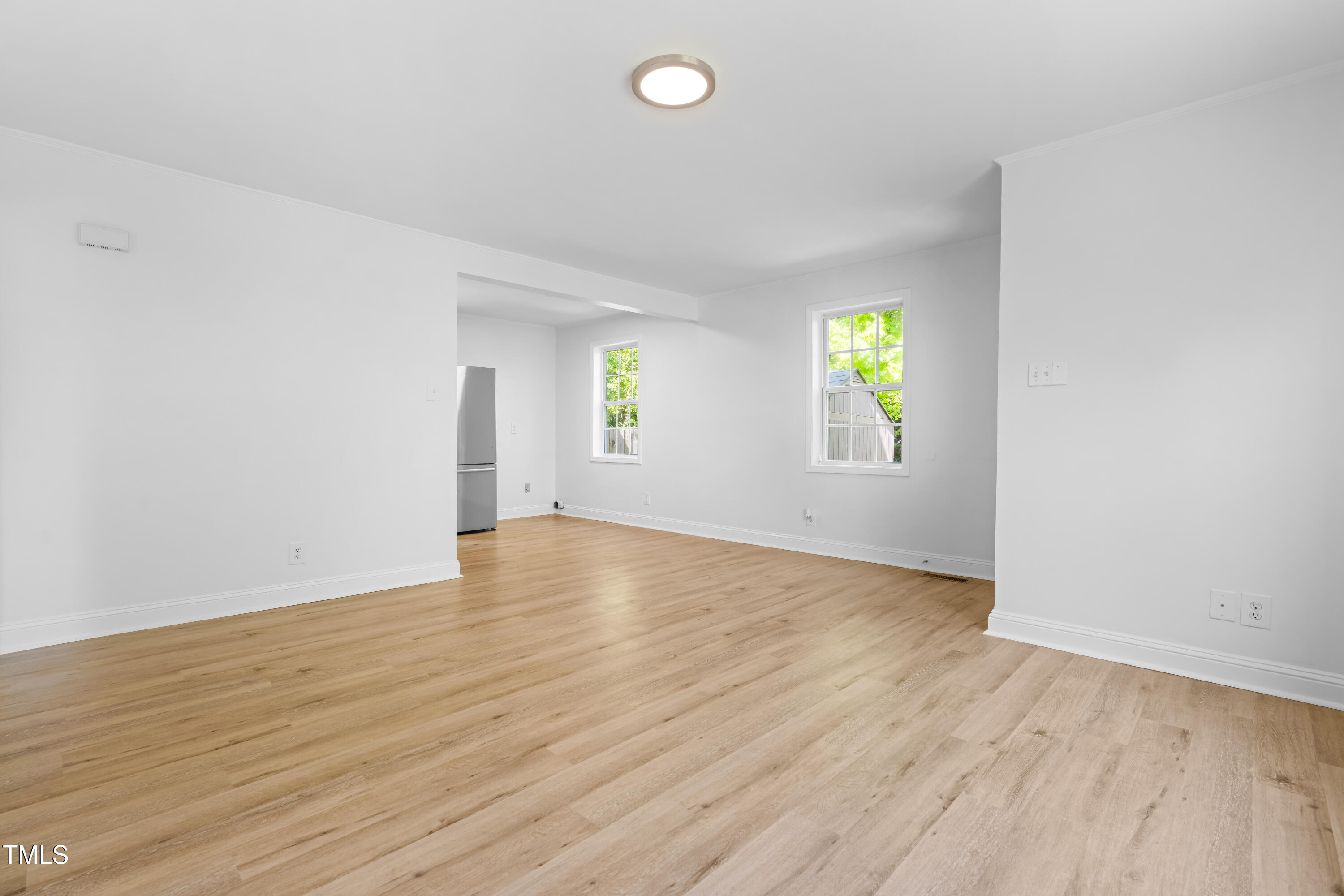 705 Hartford Road Raleigh, NC 27610 - Photo 9 of 24 an empty room with wooden floor and windows
