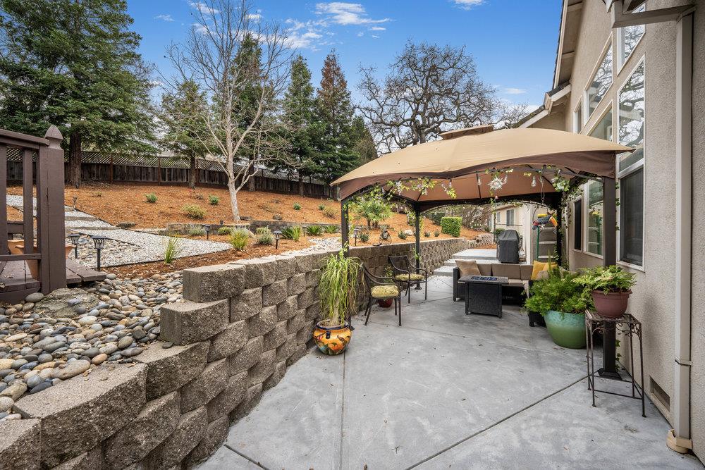 2360 Sunflower Circle Gilroy, CA 95020 - Photo 36 of 49 a view of a patio with table and chairs under an umbrella with a fire pit