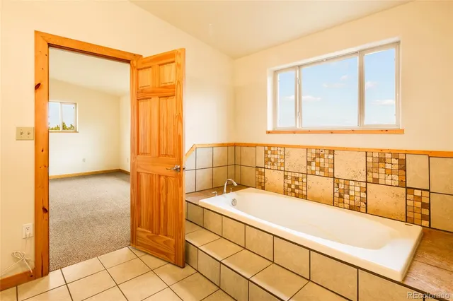 a bathroom with a bathtub and next to a window