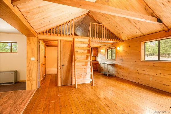 a kitchen with stainless steel appliances granite countertop a refrigerator a sink dishwasher a stove and a dining table with wooden floor