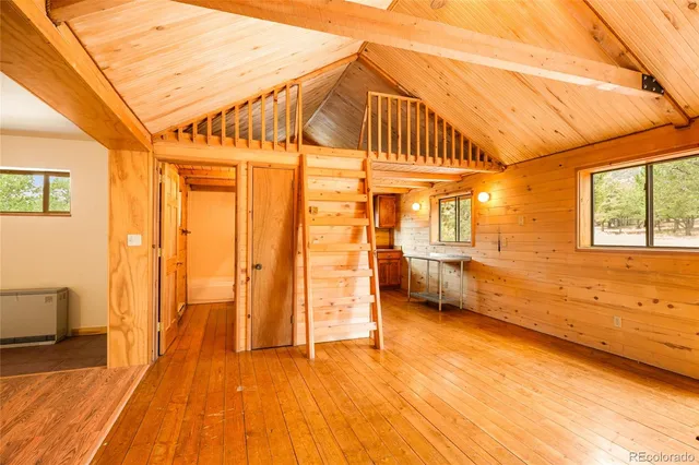 a kitchen with stainless steel appliances granite countertop a refrigerator a sink dishwasher a stove and a dining table with wooden floor