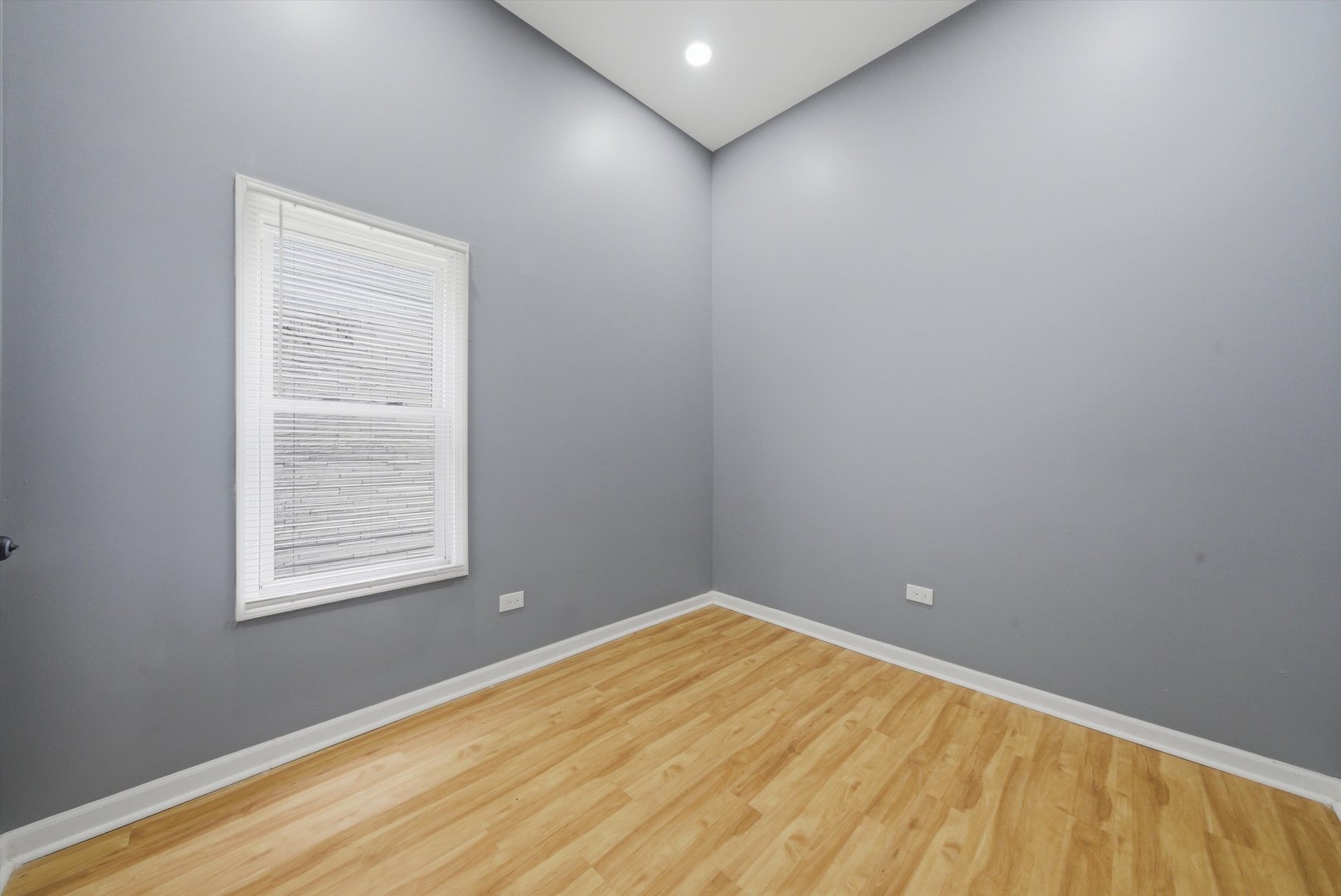 7828 South Escanaba Avenue Chicago, IL 60649 - Photo 9 of 41 a view of an empty room with wooden floor and a window