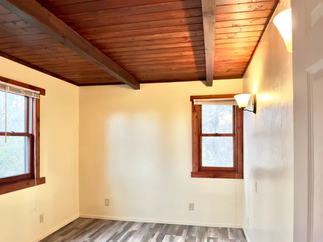 a front view of house with yard and trees in the background