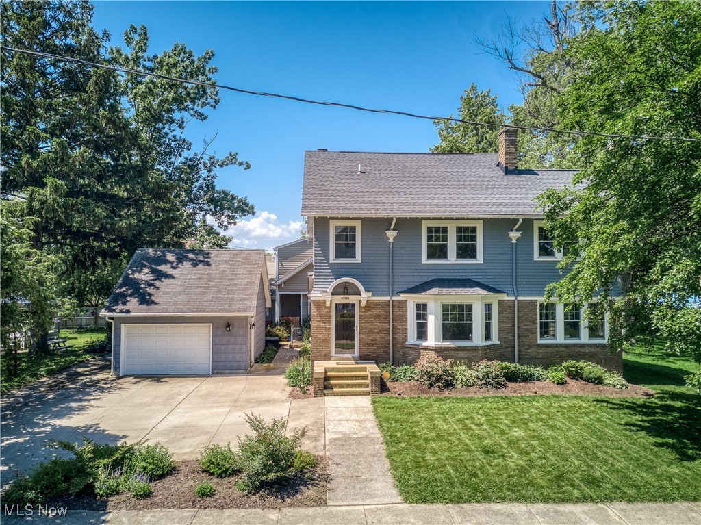 17728 Windward Road Cleveland, OH 44119 - Photo 1 of 32 View of front of property with a chimney, a front yard, concrete driveway, roof with shingles, and an outdoor structure