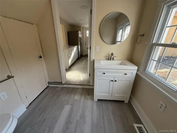 a bathroom with a sink a toilet and a mirror